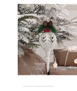 Detailed view of white Christmas ornament with pine cones and berries on a snowy tree