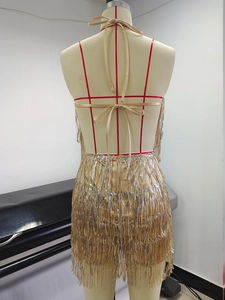 Detail showing the backless halter design and golden sequin tassels on the dress