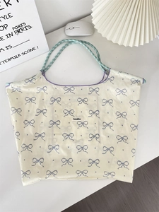 Macro detail of tote bag showing purple bow patterns and green checkered woven handles