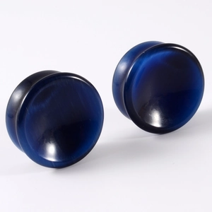 Detailed view of smooth blue stone ear gauges with cat eye opal texture and concave shape