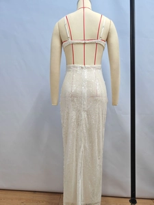 Detail of white sequin mermaid evening gown showing backless design and thin straps