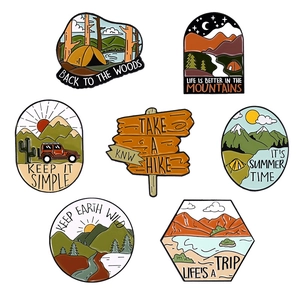 Set of outdoor adventure enamel pins featuring mountains, tents, and wilderness designs