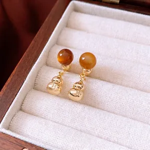Golden gourd drop earrings with amber beads in a wooden jewelry display box