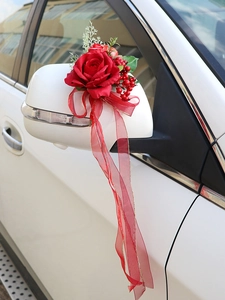 Close-up of red silk rose and berries on car side mirror for wedding car decoration