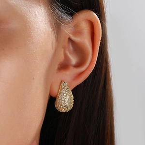 Elegant gold-tone drop earrings with full white zircon inlay shown on model