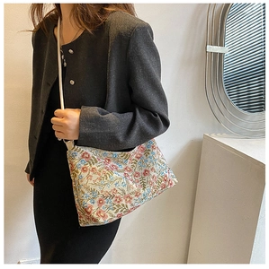 Detailed view of vintage floral tote bag with canvas texture and white faux leather strap