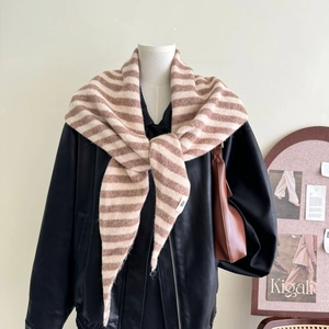 Detail of wool blend striped knit scarf draped as a shawl over a leather jacket