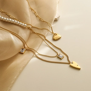 Collier doré multicouche avec pendentif cœur perles et zircon sur fond de soie