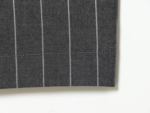 Gros plan du tissu de costume à rayures montrant les coutures et la texture grise