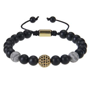 Detail of beaded bracelet with matte black stones, marble accents, and a gold zircon sphere