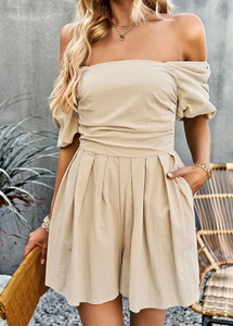 Detail of beige off-shoulder romper with puff sleeves and pleated design for summer