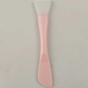 Close-up of pink silicone face mask brush with white applicator head for DIY skincare