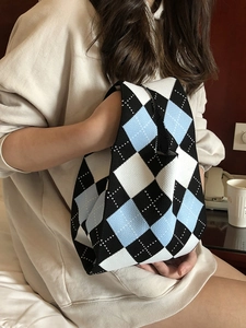 Detailed texture of knit tote bag featuring a blue and white checkered diamond pattern