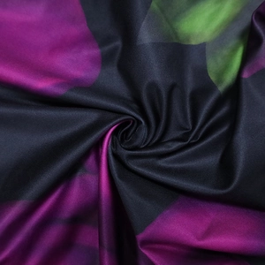Close-up of black fabric with purple floral print and detailed twill weave texture
