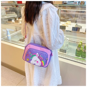 Close-up of unicorn crossbody bag with adjustable rainbow strap on a white dress model