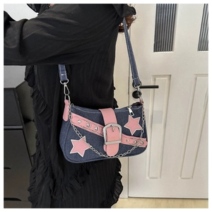 Detail of Y2K denim star underarm bag with pink leather trim and decorative silver chain