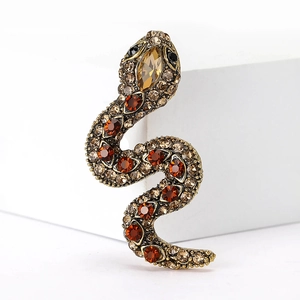 Detailed view of snake brooch with champagne rhinestones and amber crystals on bronze base