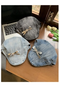 Detailed top view of three denim beret hats in black and blue with silver bow accents