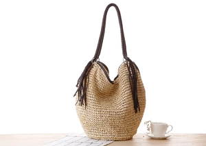 Détail du sac hobo en paille avec bandoulière en cuir tressé et longues franges