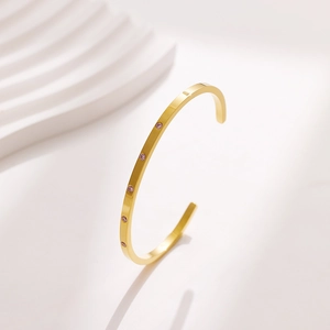 Detail of 18k gold plated stainless steel cuff bracelet with pink zircon stone inlay