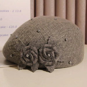 Detailed close-up of dark grey wool beret with mesh veil and 3D rose flower accents