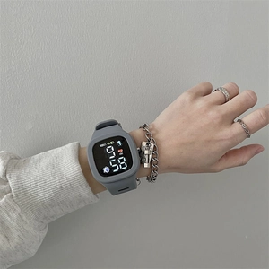 Close-up of a gray LED touch screen sports watch with silicone strap on a wrist