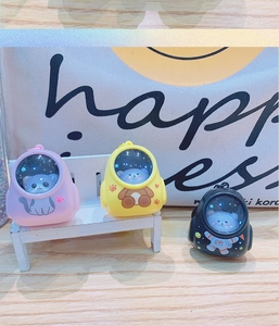 Close-up of cute glowing cartoon backpack keychains in cat and bear styles on a mini bench