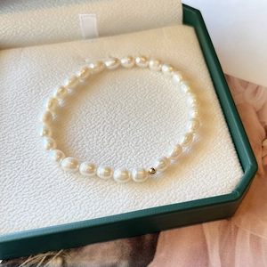 Minimalist natural freshwater pearl bracelet with 14K gold-filled bead on green jewelry box
