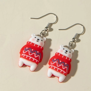 Détail de boucles d'oreilles en résine d'ours blanc portant un pull rouge de Noël