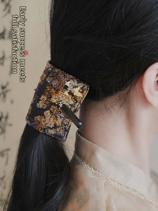 Detail of embroidered floral hair bun cover with butterfly pattern and wooden hair stick