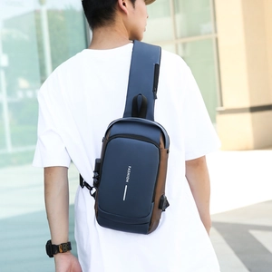 Waterproof navy blue men's sling bag with security lock and USB port shown on model
