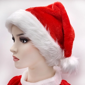 Close-up of red plush Christmas hat with white faux fur trim and pompom worn by model