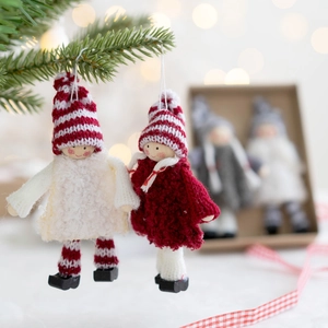 Knitted wool felt angel ornament hanging on a Christmas tree with wooden details