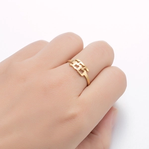 Macro shot of gold stainless steel ring with cutout 555 angel number on hand