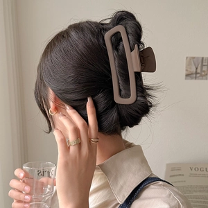 Brown rectangular matte claw clip for women's bun hairstyle shown on a model