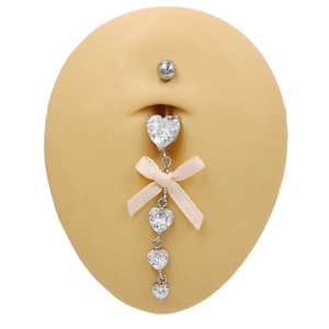 Détail de piercing nombril argenté avec zircons en cœur et un nœud en soie rose