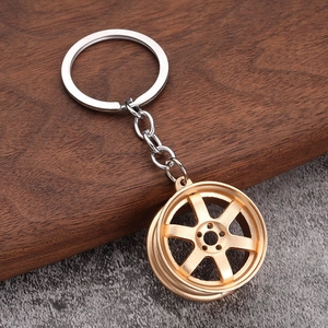 Detail of creative gold car wheel rim keychain with six-spoke design and metallic finish