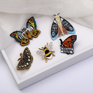 Lot de 5 broches en émail représentant des papillons colorés et une abeille