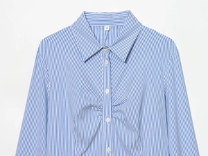 Detail of blue and white striped shirt featuring lapel collar and ruched chest design