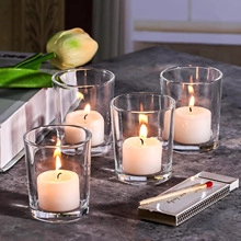 Detailed view of four ribbed glass candle holders on marble surface with soft lighting