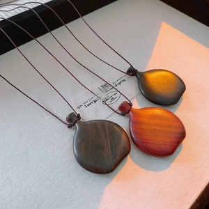 Detailed view of polished gourd-shaped wood pendants with fine grain and woven cords