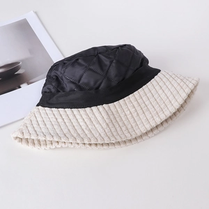Detailed flat lay of quilted black crown and beige corduroy brim bucket hat with ribbon