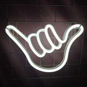 White Shaka hand gesture LED neon sign hanging on a grid wall for room decor