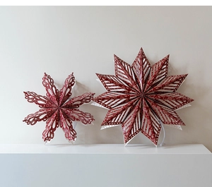 Close-up of red and white 3D paper snowflake stars with glitter for Christmas decor
