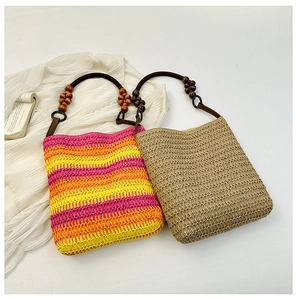 Close-up of rainbow striped straw bucket bag and khaki tote with wooden beaded handles