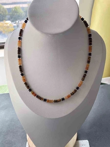 Detail of bohemian handmade beaded necklace featuring orange and brown abacus beads