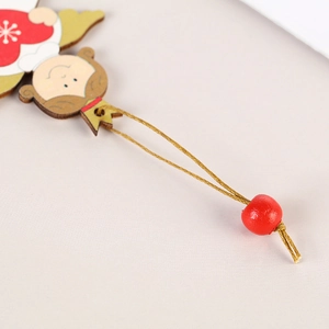 Christmas wooden angel ornament with red heart and gold wings on a pink background