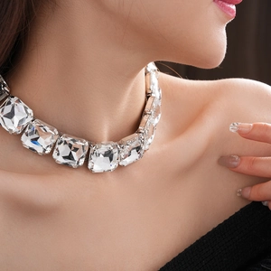 Primo piano di una collana in argento con cristalli quadrati indossata da una modella