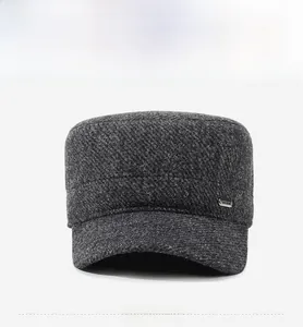 Dettaglio frontale del berretto invernale da uomo in tweed grigio con logo in metallo