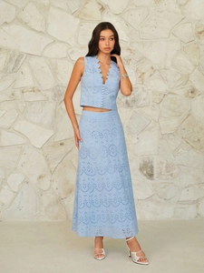 Detail of light blue eyelet embroidery and wavy edge hem on a two-piece skirt set